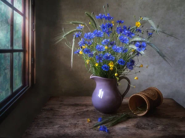 Rural still life with bouquet of cornflowers