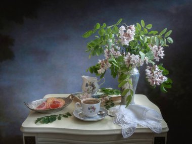 Kahve masasında akasya dallarıyla dolu bir hayat.