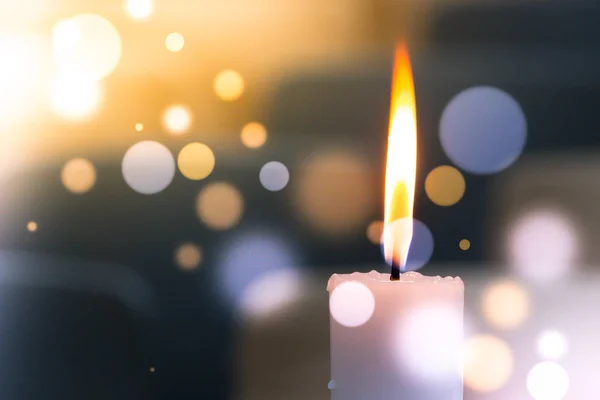 Bir ışık mum bokeh arka planda parlakça yanıyor.