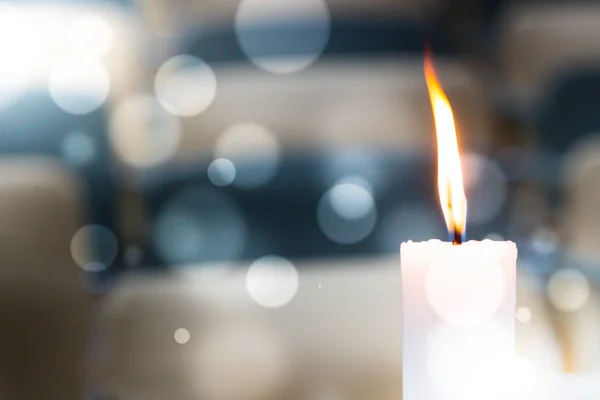 Bir ışık mum bokeh arka planda parlakça yanıyor.