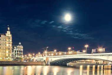 Gece Sofiyskaya dolgu ve Bolshoy Moskvoretsky Köprüsü manzarasına. Dolunay şehri