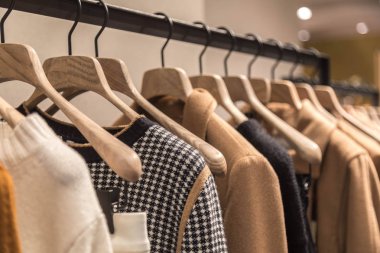 Dükkanda sonbahar kadın giyimi olan askılar. bej renkler