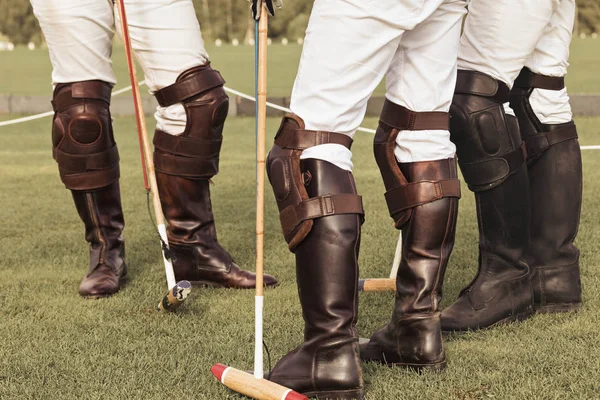 Un grupo de jugadores de polo ecuestre profesionales masculinos. Botas altas de cuero marrón, nudillos protectores, martillo y latigazo en las manos de los jinetes —  Fotos de Stock