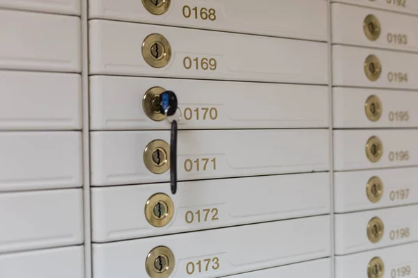 Storage with rows of individual deposit boxes in the bank. One Key in a lock of the door