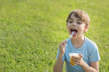 Beyaz çocuk sıcak yaz gününde dondurma yiyor.
