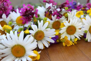 bir masanın üzerinde yatan kır çiçekleri buketi