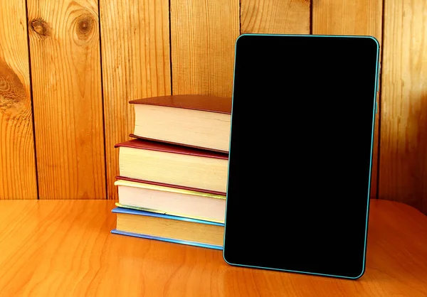 Kitaplar ve bir tablet masaya vardır