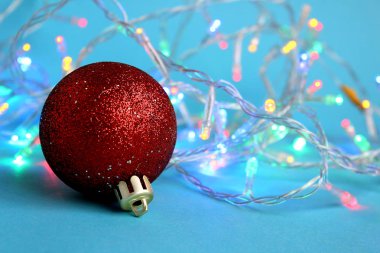 Parlak bir top şeklinde bir oyuncak ile mavi bir arka plan üzerinde renkli garland