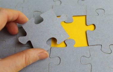 El Gri bulmaca sarı arka plan üzerinde tutar.