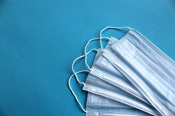 Mavi arka planda beyaz tıbbi maske