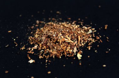 masanın üzerinde bir yığın ezilmiş tütün yaprakları vardır