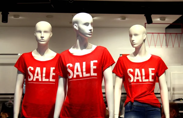 Orada üç mankenler dükkanda kelime Satılık olan kırmızı bir tişört