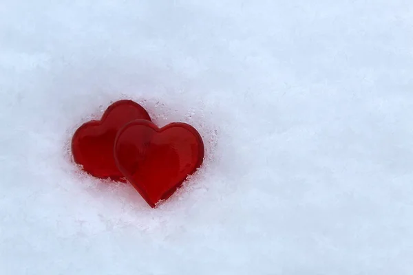 Dvě Červené Plastové Srdce Jsou Bílém Sněhu — Stock fotografie
