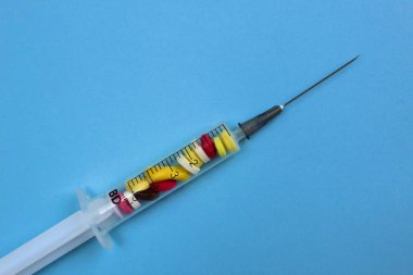 Bir şırınga hangi içinde olan tablet bir mavi arka plan yalanlar üzerine