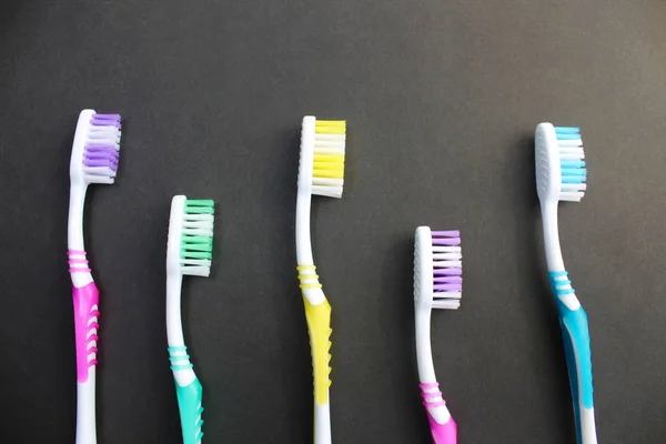 Cepillos Dientes Multicolores Yacen Sobre Fondo Negro — Foto de Stock