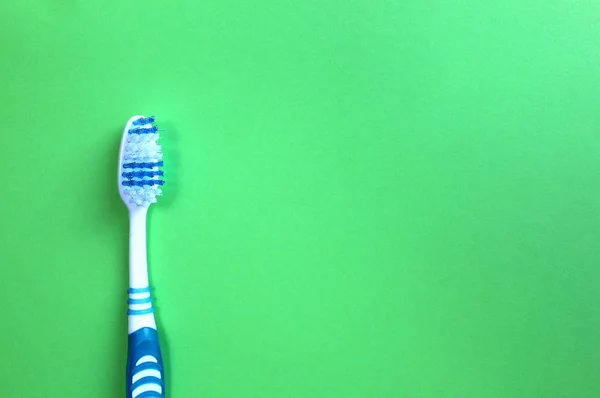 Een Tandenborstel Ligt Een Groene Achtergrond — Stockfoto