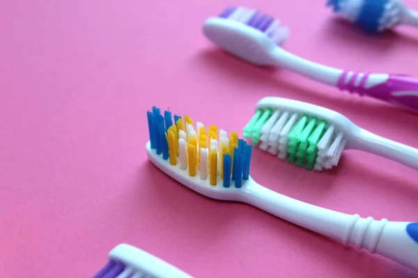 Çok Renkli Diş Fırçaları Pembe Arka Plan Üzerinde Yatıyor — Stok fotoğraf