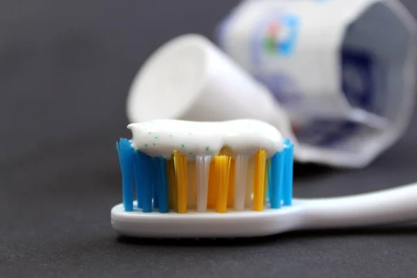toothpaste and brushes on a black background