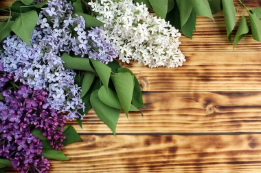 Ahşap bir masa üzerinde leylak birkaç dalları vardır