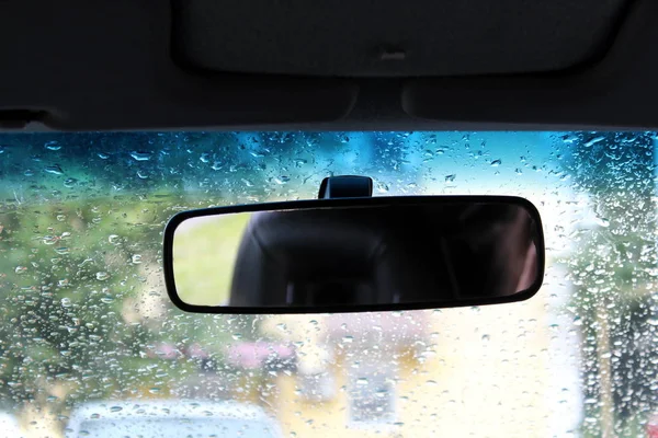 Rearview mirror in the car on a rainy day