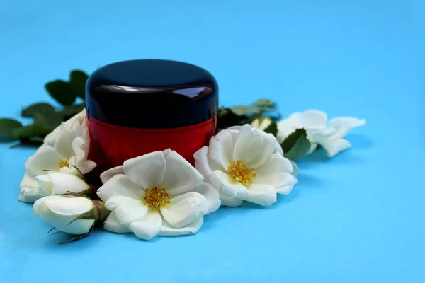 Crema Una Botella Rodeada Flores Blancas Rosa Silvestre —  Fotos de Stock