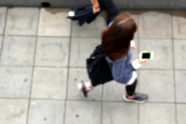 Θολή Φωτογραφία Ενός Κοριτσιού Που Περπατά Και Κρατώντας Ένα Τηλέφωνο — Φωτογραφία Αρχείου