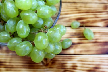 bir cam tabak üzerinde yatan taze yeşil üzüm demetleri