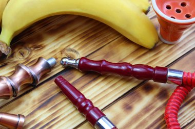 kırmızı nargile boru bir ahşap bir muz yanında yatıyor