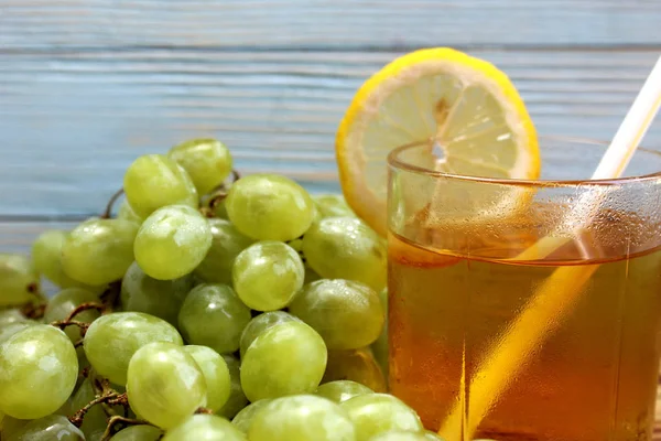 glass of fresh grape juice with grapes on the background