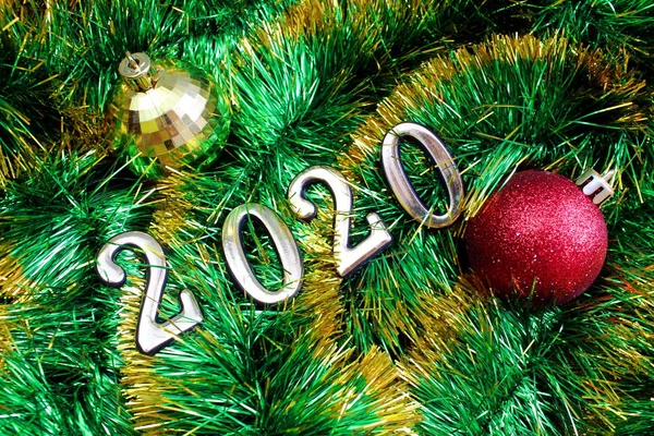 テクスチャ光沢のあるクリスマスの緑のティンセルクリスマスのおもちゃと番号2020 — ストック写真