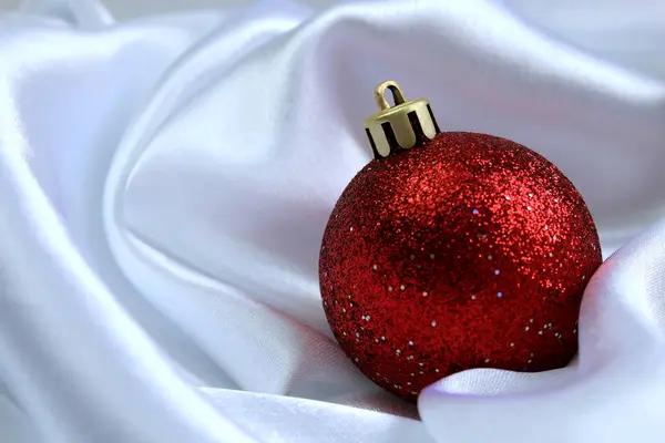 Red Shiny Christmas Toy Lies White Cloth — Stock Photo, Image