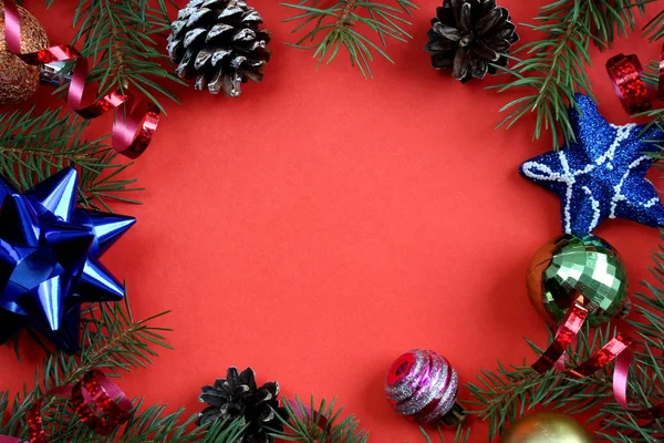 クリスマスのテクスチャモミの枝 おもちゃ 赤い背景のコーン — ストック写真