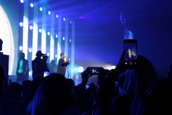 콘서트 스탠드에서 사람들의 사진을 흐릿하게 전화로 — 스톡 사진