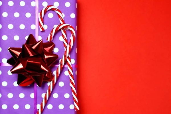 gift box with a sweet cane on a red background