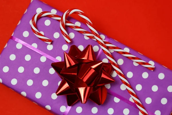 gift box with a sweet cane on a red background