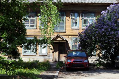 Modern araba eski harap olmuş iki katlı evde duruyor.