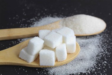 Siyah arka planda tahta kaşıkta kırılabilir şeker