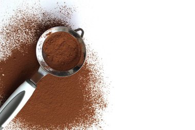 Beyaz arka planda süzgeci olan kakao tozu