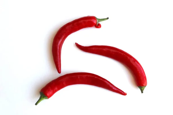 Három Piros Chili Paprika Fekszik Egy Fehér Felületen — Stock Fotó