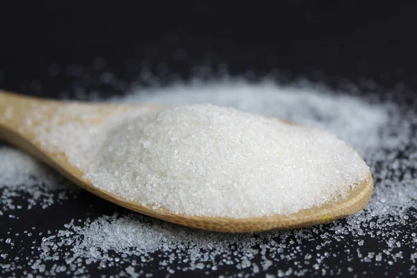 Brühbarer Zucker Auf Einem Holzlöffel Auf Schwarzem Hintergrund — Stockfoto