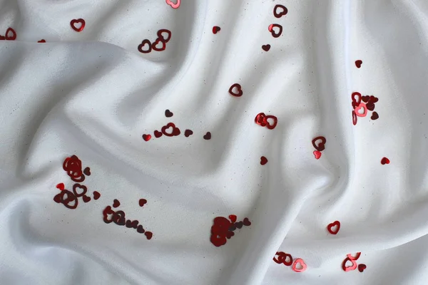 Czerwone Konfetti Kształcie Serca Leży Białej Satynowej Tkaninie — Zdjęcie stockowe