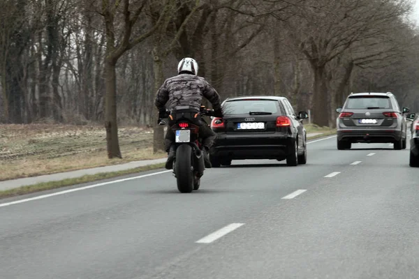 Een Motorfiets Rijdt Achter Een Auto Bij Inhalen — Stockfoto