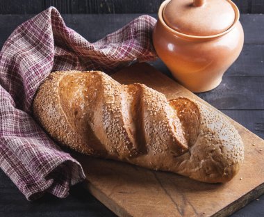 Taze somun ahşap bir masaya susam serpilir. Delici