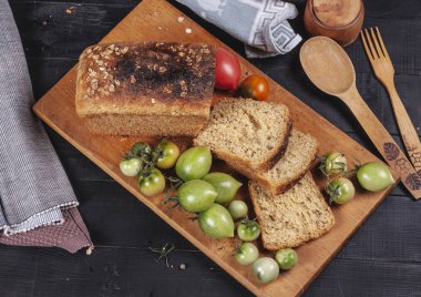 Mutfak tahtasında taze ekmek ve taze domates