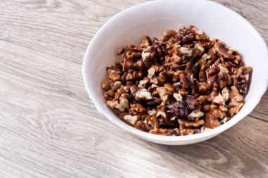 Yuvarlak beyaz tabakta soyulmuş fındık. Sağlıklı yemek.