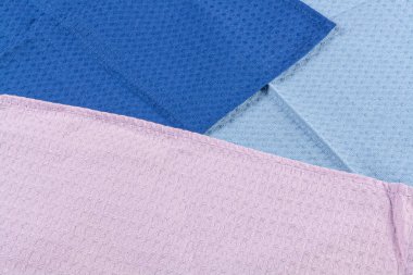 Koyu ahşap arka planda renkli mutfak havluları.