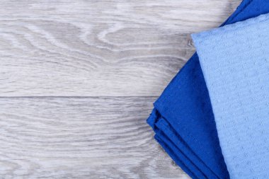 Koyu ahşap arka planda renkli mutfak havluları.