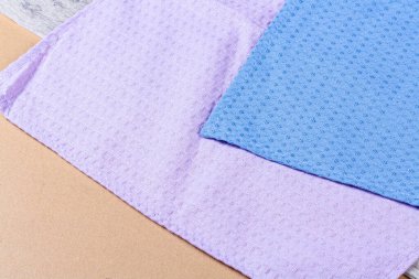 Koyu ahşap arka planda renkli mutfak havluları.