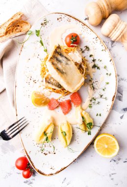 Greyfurt, limon ve patates püresi patates pasta üzerinde beyaz balık pişmiş bonfile
