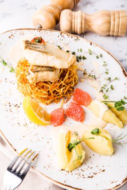 Greyfurt, limon ve patates püresi patates pasta üzerinde beyaz balık pişmiş bonfile